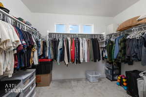 Walk in closet featuring light carpet