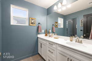 Bathroom featuring double vanity, plenty of natural light, and light tile patterned floors