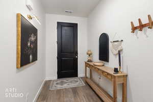 Doorway to outside featuring wood finished floors and baseboards