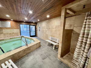 Bathroom with tile walls, a stall shower, a bath, recessed lighting, and tile patterned floors