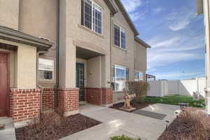 View of exterior entry with stucco siding and brick siding