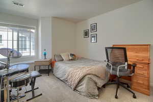 Bedroom featuring light carpet and window seat