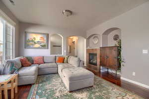 Living area with hardwood / wood-style floors, a fireplace, and arched walkways