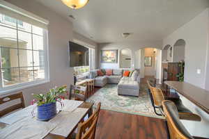Dining area with dark wood-style flooring, a fireplace, and arched walkways