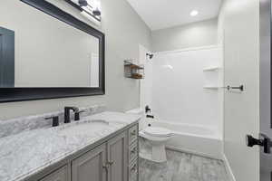 Full bath featuring vanity, light wood finished floors, and  shower combination