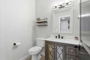 Half bathroom on main level with vanity and light wood finished floors