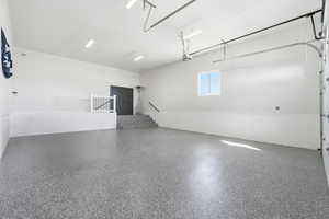 View of garage with separate entrance for basement, 220 volt outlet and stubbed for gas heater