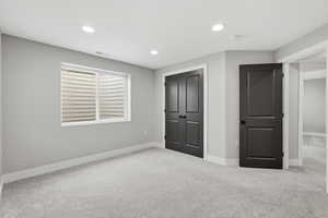 Unfurnished bedroom featuring carpet flooring, a closet, and recessed lighting
