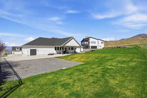 Rear view of property with extended gravel pad stubbed with electrical for potential shop or extra exterior lighting