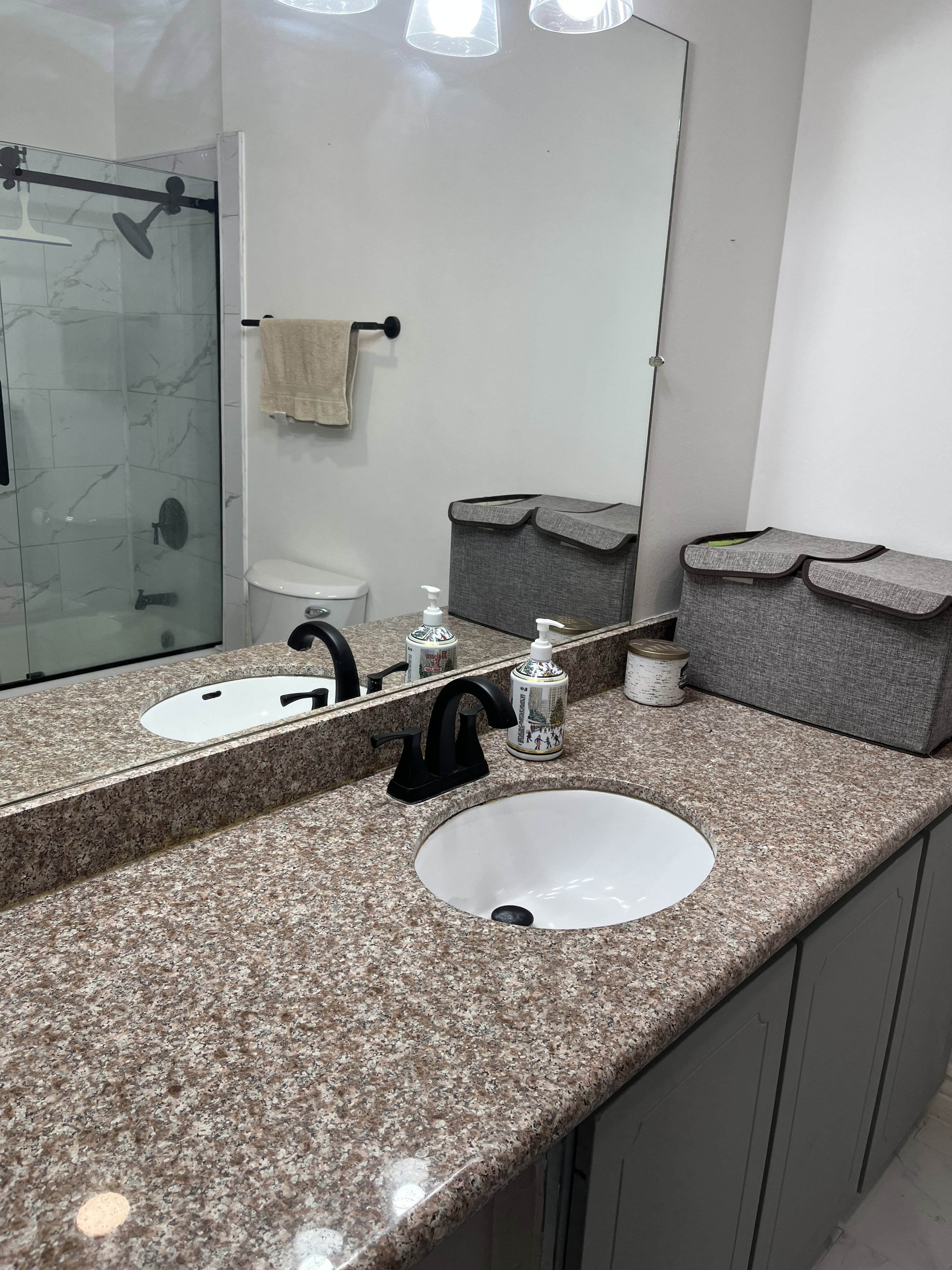Full hall bathroom with vanity and a marble finish shower