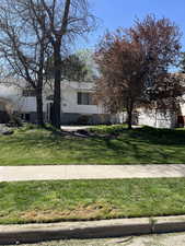 Bi-level home with brick siding and a front yard