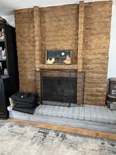 Detailed view of a brick fireplace and wood finished floors