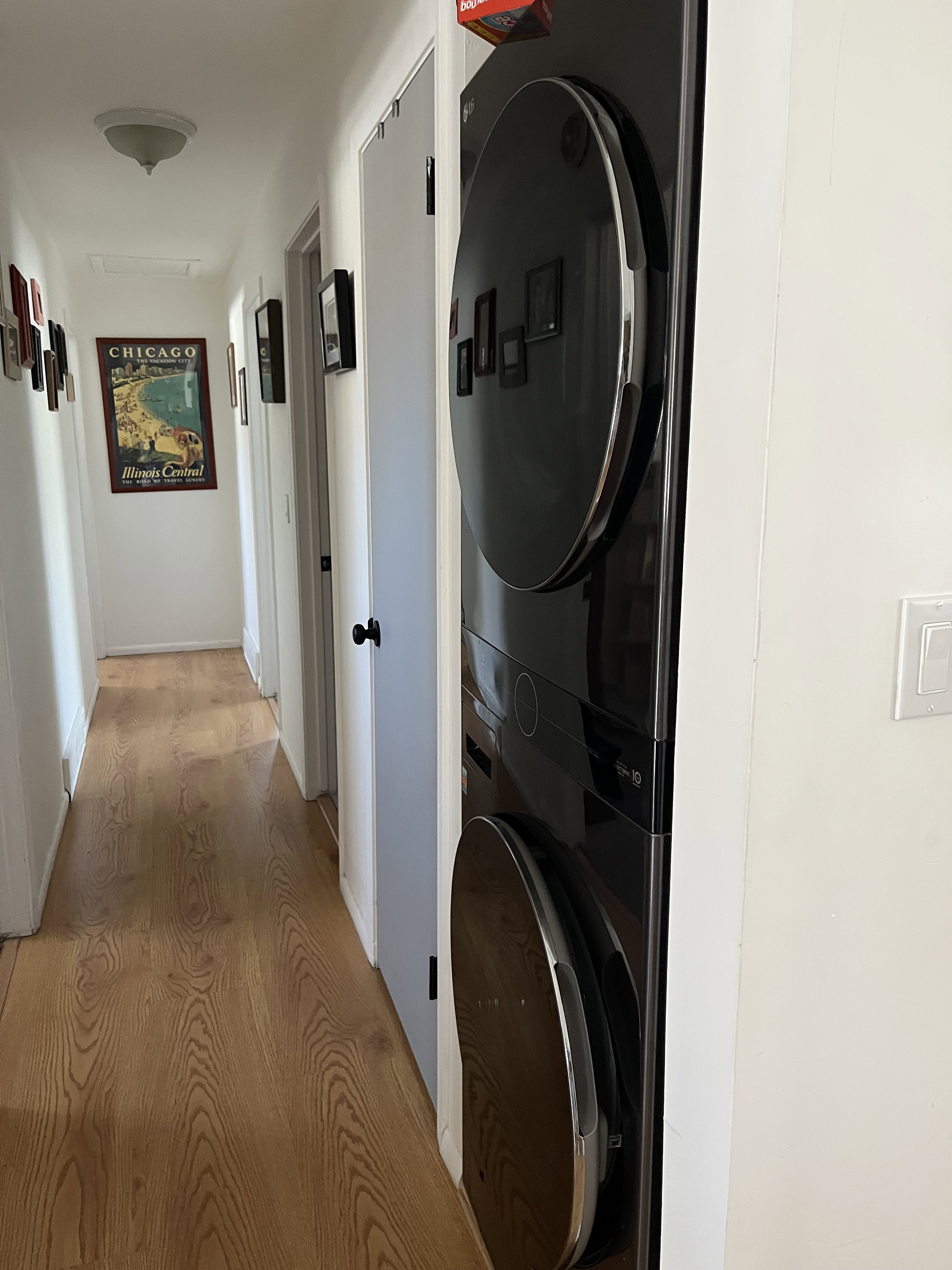 Laundry area featuring light wood finished floors and stacked washer and dryer
