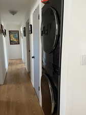 Laundry area featuring light wood finished floors and stacked washer and dryer