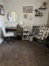 Large office/bedroom area featuring dark carpet and above ground window