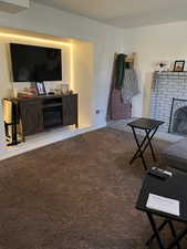 Living room featuring a brick fireplace and carpet flooring