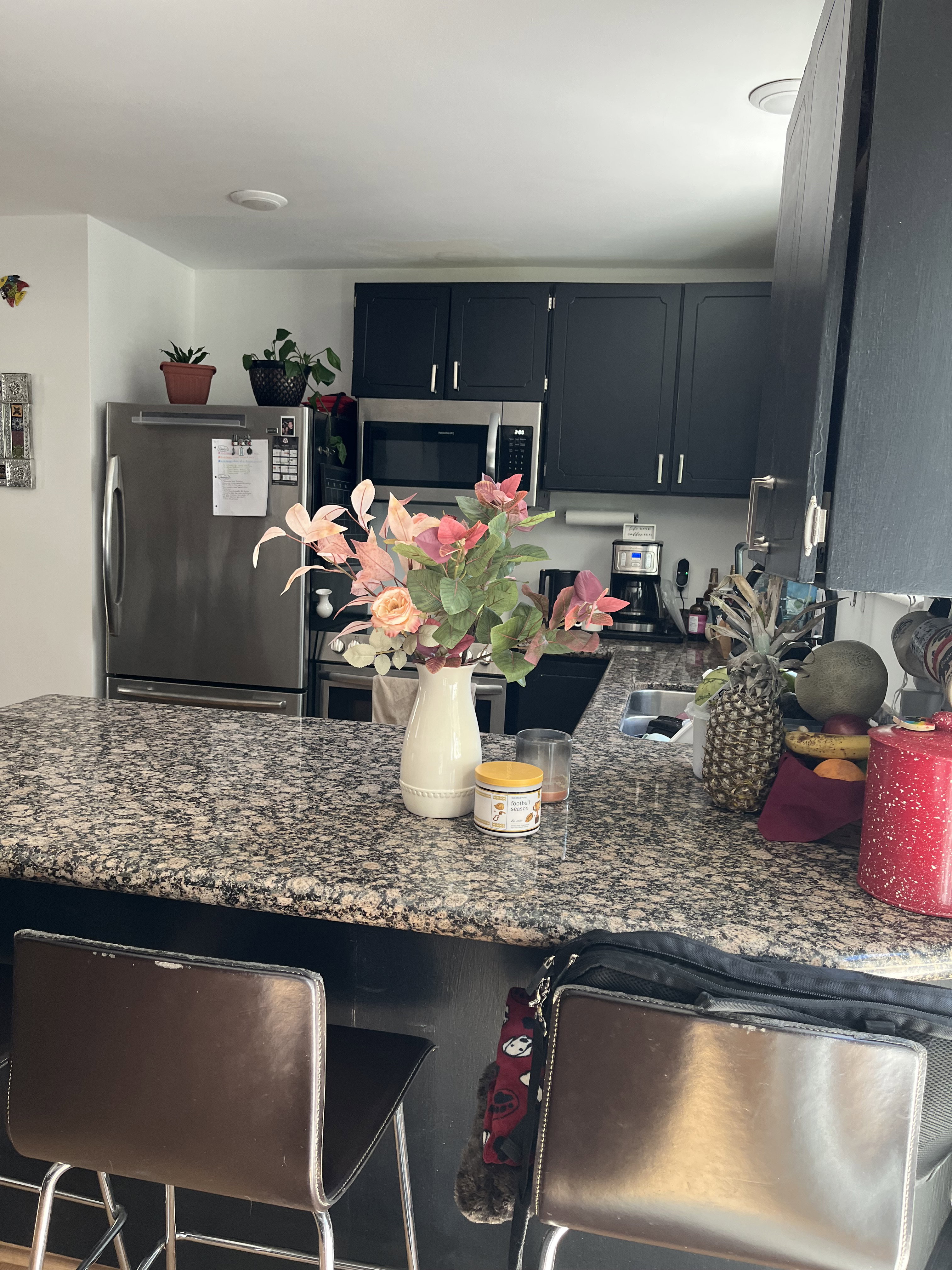 Kitchen with stainless steel appliances, granite counters, a breakfast bar, and dark cabinets