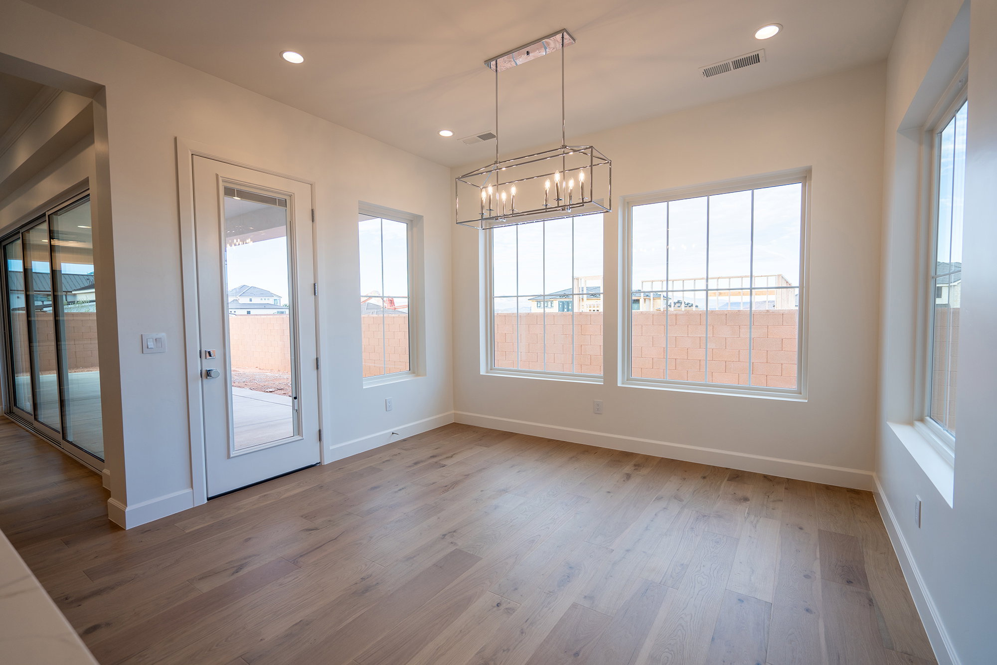 Unfurnished dining area with suspended lighting and light wood-style flooring