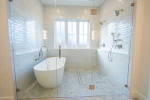 Bathroom featuring a soaking tub and a shower stall