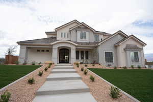 View of front facade featuring a front lawn, covered porch, and stucco siding