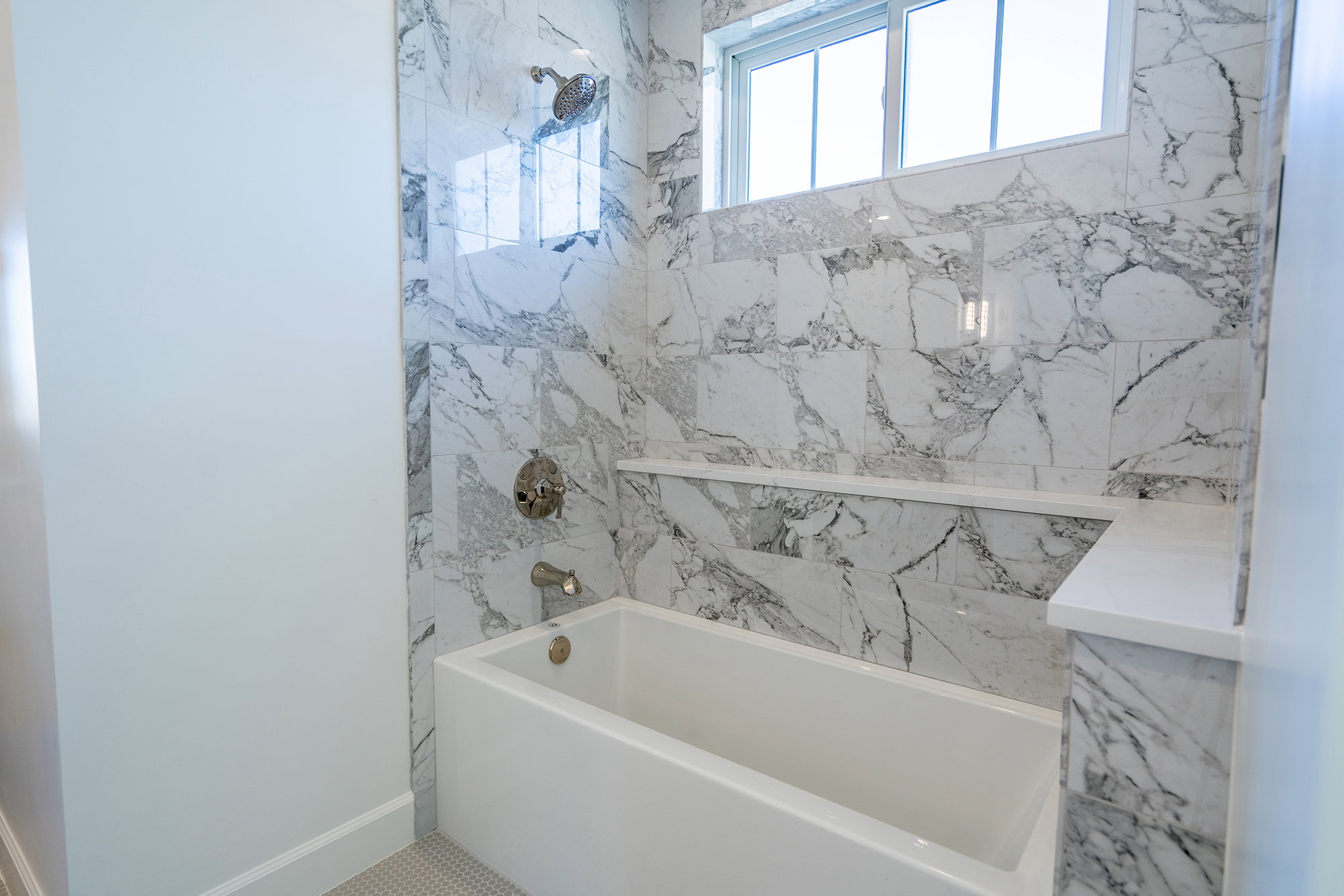 Bathroom featuring a combined bath / shower with marble appearance and baseboards