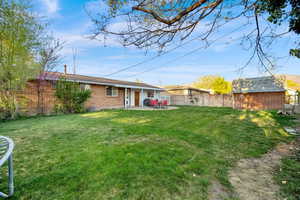 Rear view of property featuring a patio area and brick siding