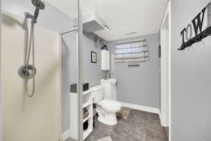 Full bathroom featuring a stall shower, a textured ceiling, and vanity