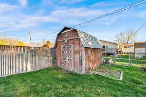 View of shed with a fenced backyard and a gate