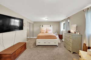 Carpeted bedroom featuring a closet