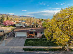 View of front facade featuring concrete driveway, a mountain view, a residential view, covered porch, and a garage