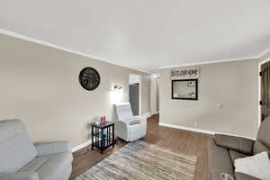 Sitting room featuring wood finished floors and crown molding