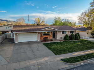 Single story home featuring driveway, a garage, roof with shingles, and brick siding