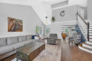 Living room featuring dark wood-style floors and vaulted ceiling