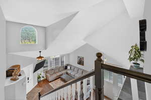 Living room featuring healthy amount of natural light, a high ceiling, and wood finished floors