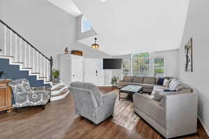 Living room with wood finished floors, healthy amount of natural light, and a high ceiling