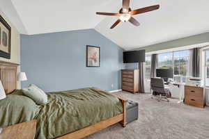 Carpeted bedroom with a ceiling fan and an office area