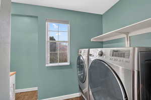 Laundry room featuring washer and clothes dryer and dark wood-style flooring