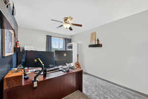 Carpeted office featuring baseboards and ceiling fan