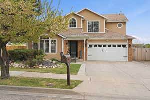 Traditional home featuring stucco siding, driveway, and brick siding