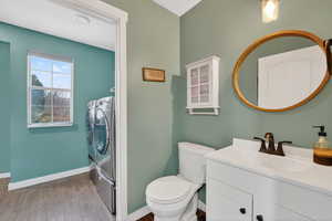 Bathroom with a shower stall, separate washer and dryer, vanity, and dark wood finished floors