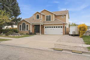 Traditional home with concrete driveway, stucco siding, and brick siding