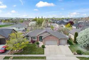 Single story home featuring an attached garage, a front lawn, a residential view, and concrete driveway