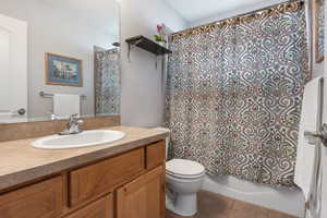 Bathroom with vanity, shower / tub combo with curtain, and light tile patterned floors