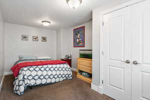 Bedroom featuring dark colored carpet and baseboards