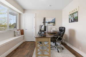 Office space featuring dark wood finished floors and baseboards