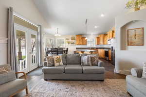 Living area featuring lofted ceiling, wood finished floors, and suspended lighting