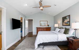 Bedroom featuring a spacious closet, dark wood-style flooring, and a ceiling fan