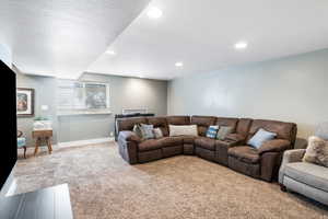 Carpeted living room with a textured ceiling and recessed lighting