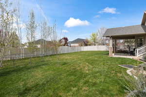 Fenced backyard featuring a trampoline and a patio