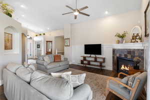 Living room featuring a fireplace, ceiling fan, wood finished floors, wainscoting, and recessed lighting